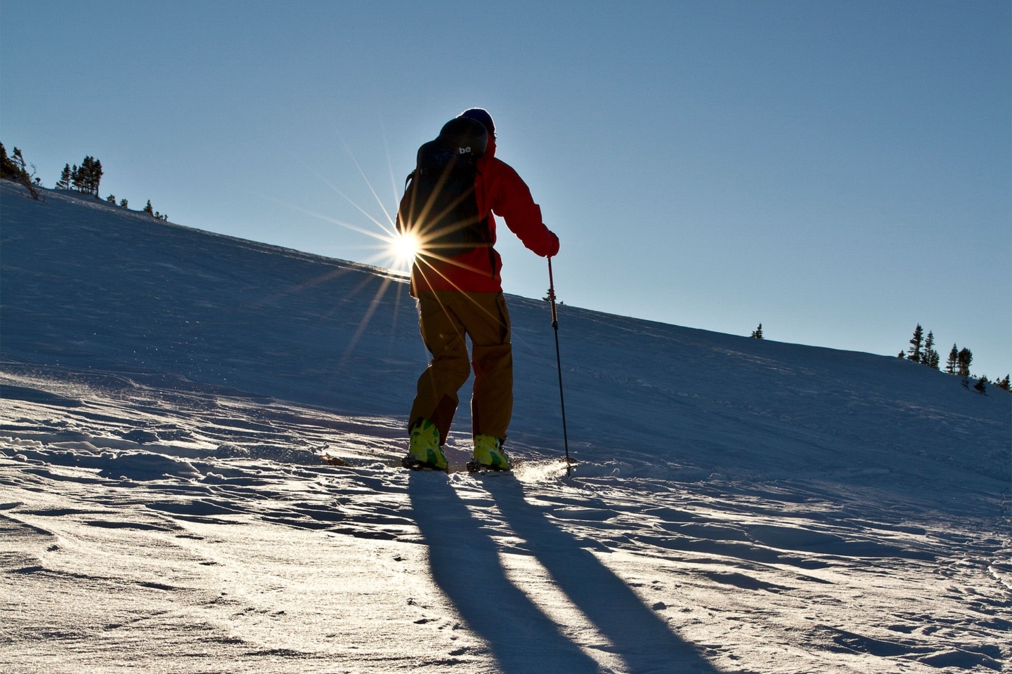 Skier walking up a snowy mountain slope