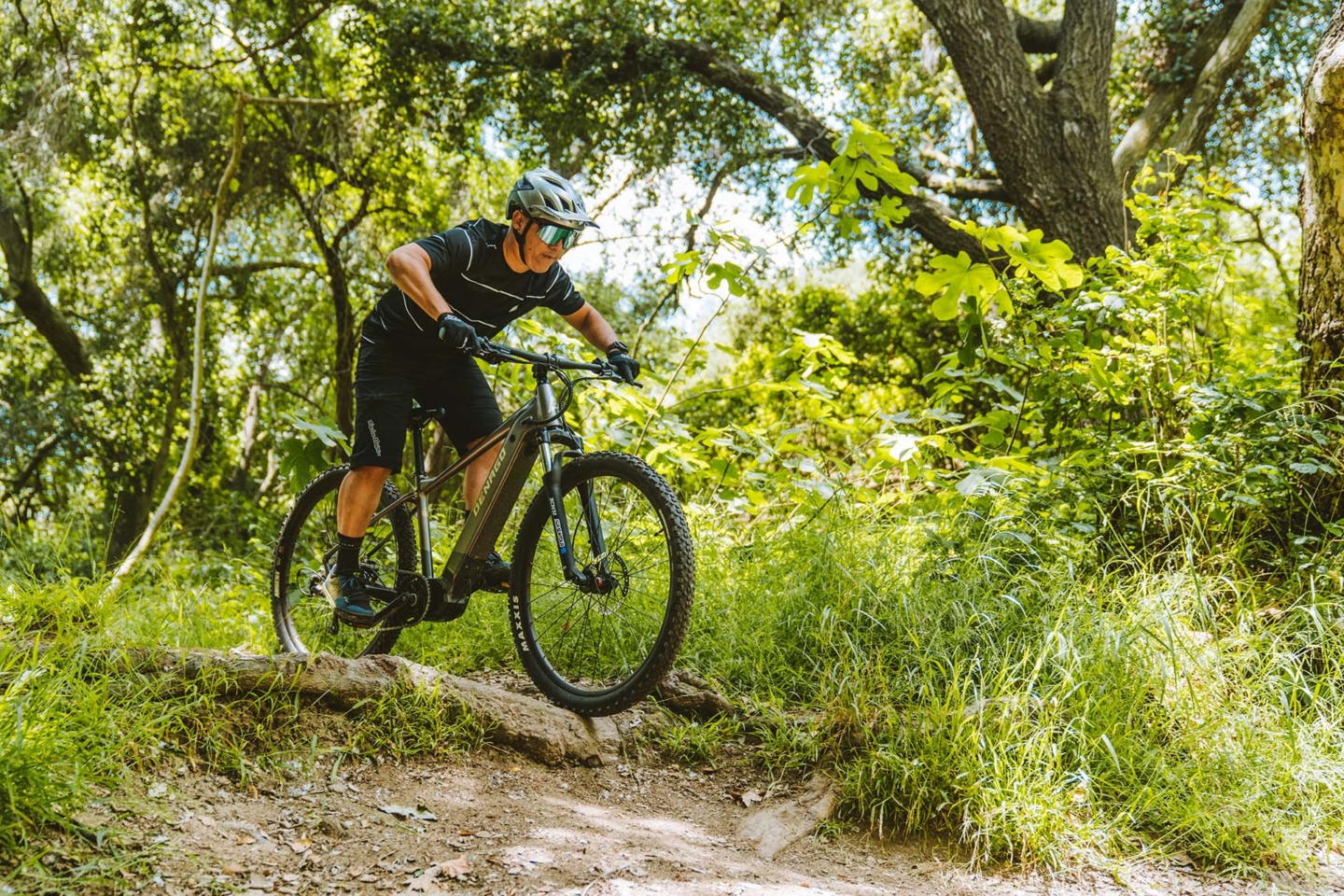 Man on mountain e-bike riding a trail through the woods